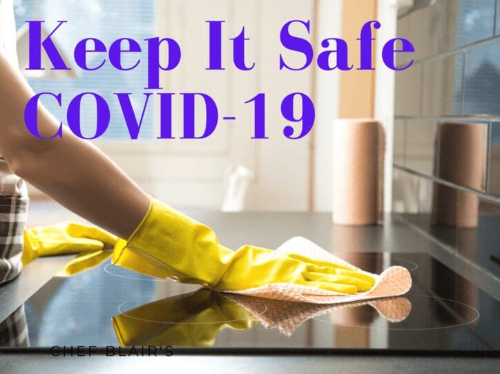 A person wearing yellow gloves cleaning the counter.